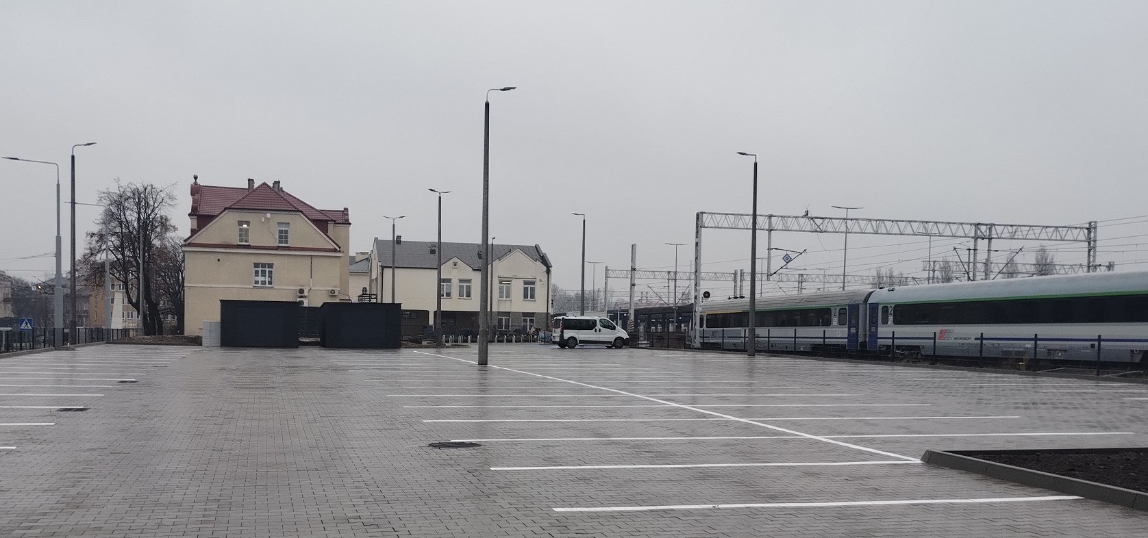 Nowy parking przy stacji Lublin Główny na chwilę przed otwarciem, widać pociąg i budynek dworca, fot. K. Różewicz.jpg